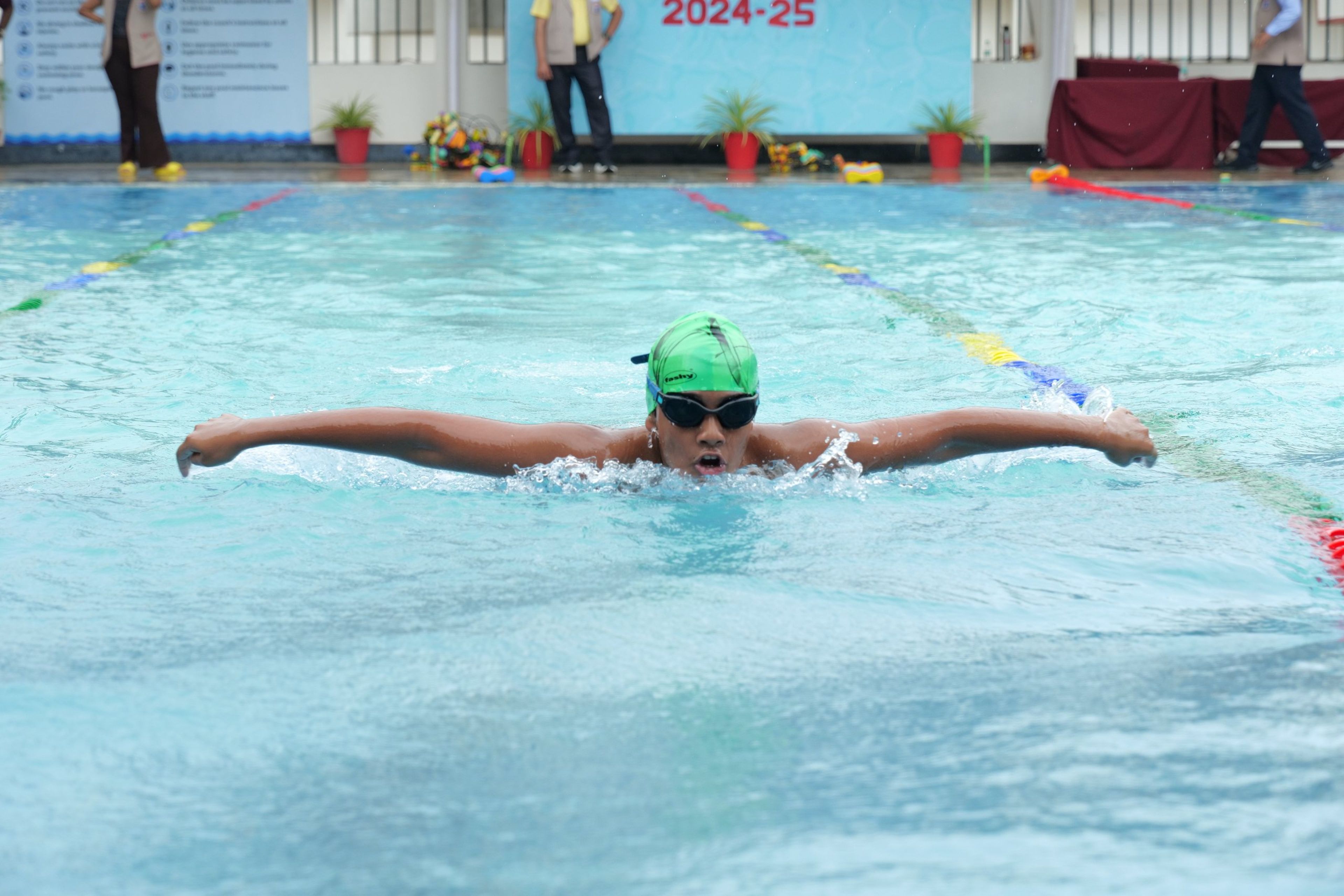 A student swimming butterfly in the school pool