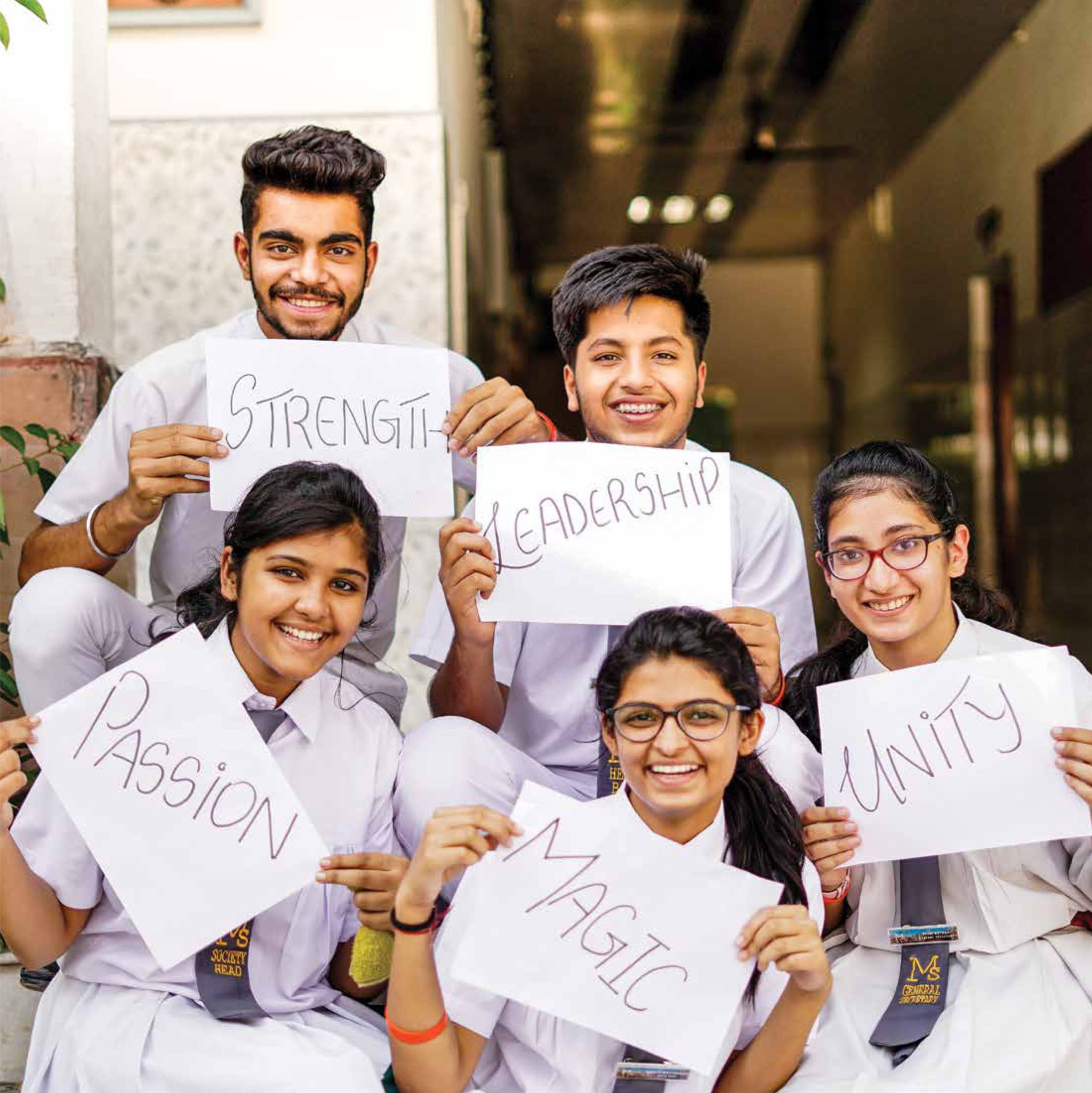 Senior students holding signs reading Strength, Leadership, Passion, Magic and Unity
