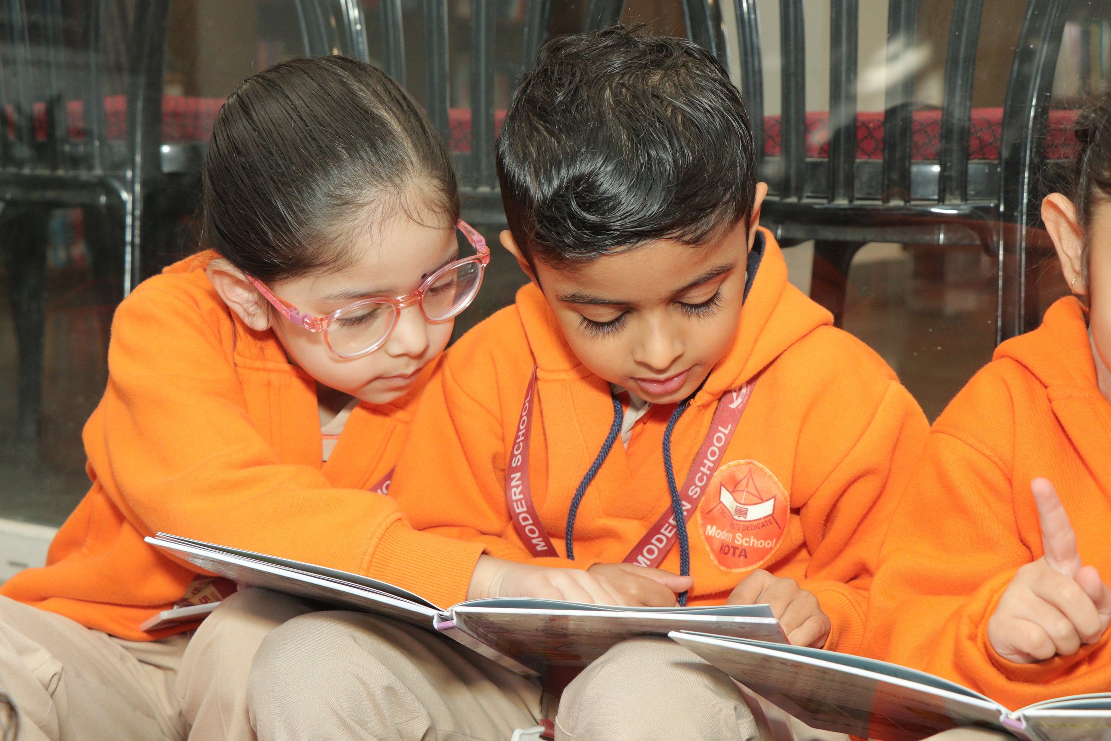 Two young children reading picture books together