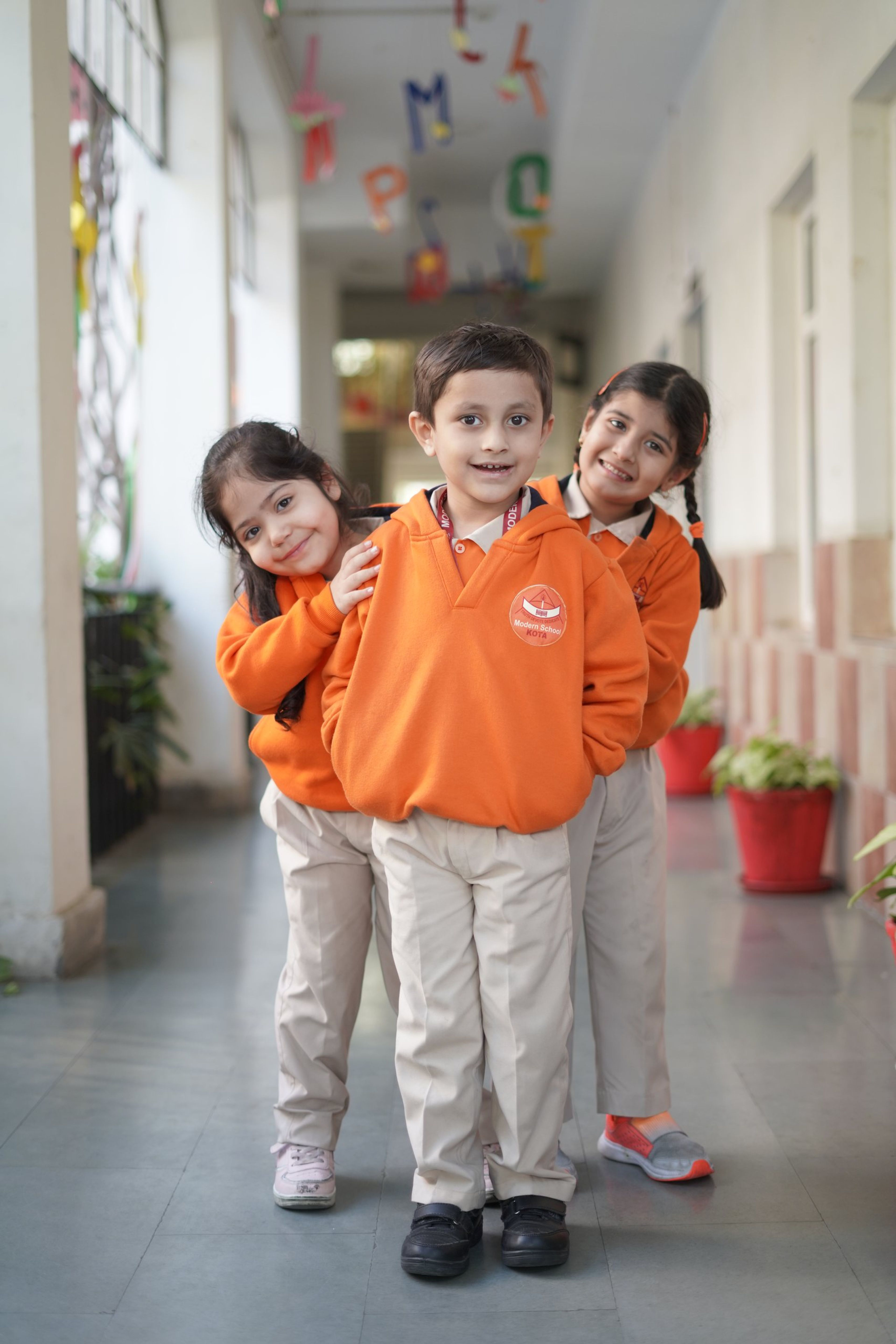 Three pre-primary children in a school corridor