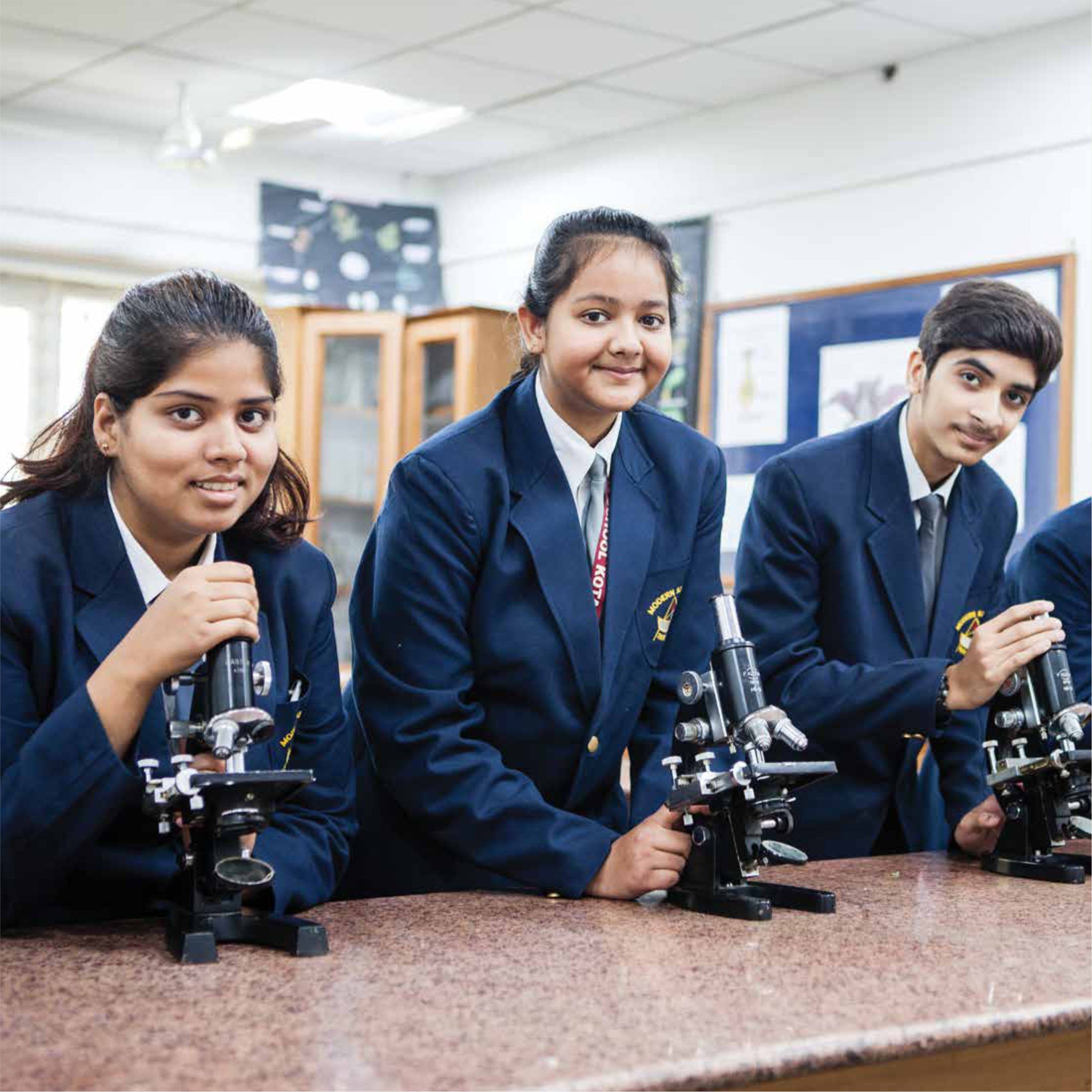 Senior students with microscopes in the biology lab