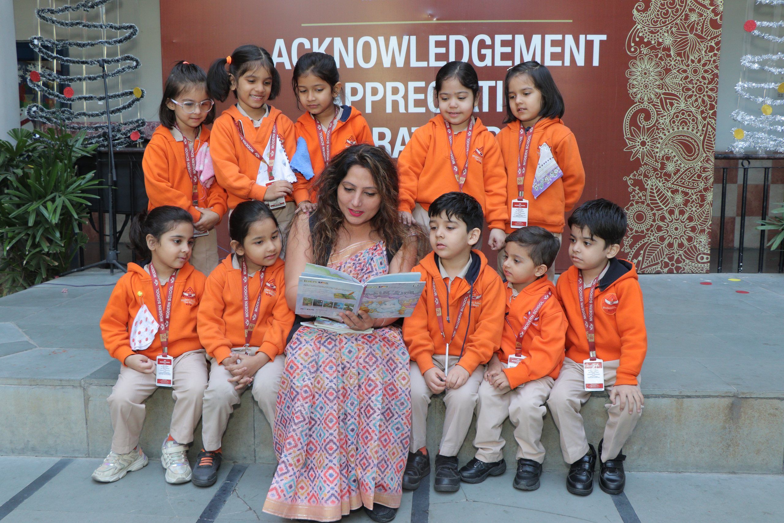 A teacher reading a picture book to a group of young pupils