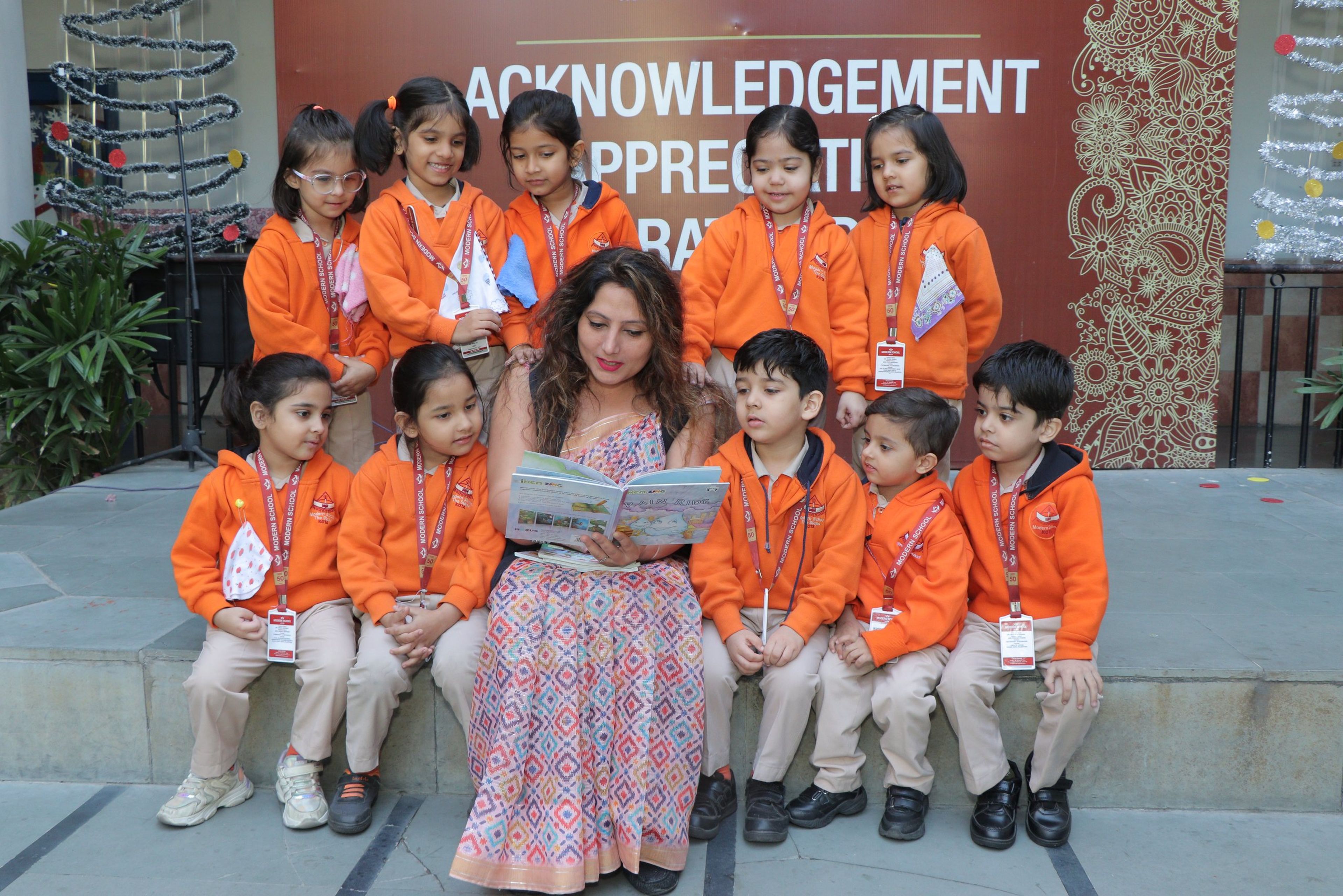 A teacher reading a picture book to a group of young pupils