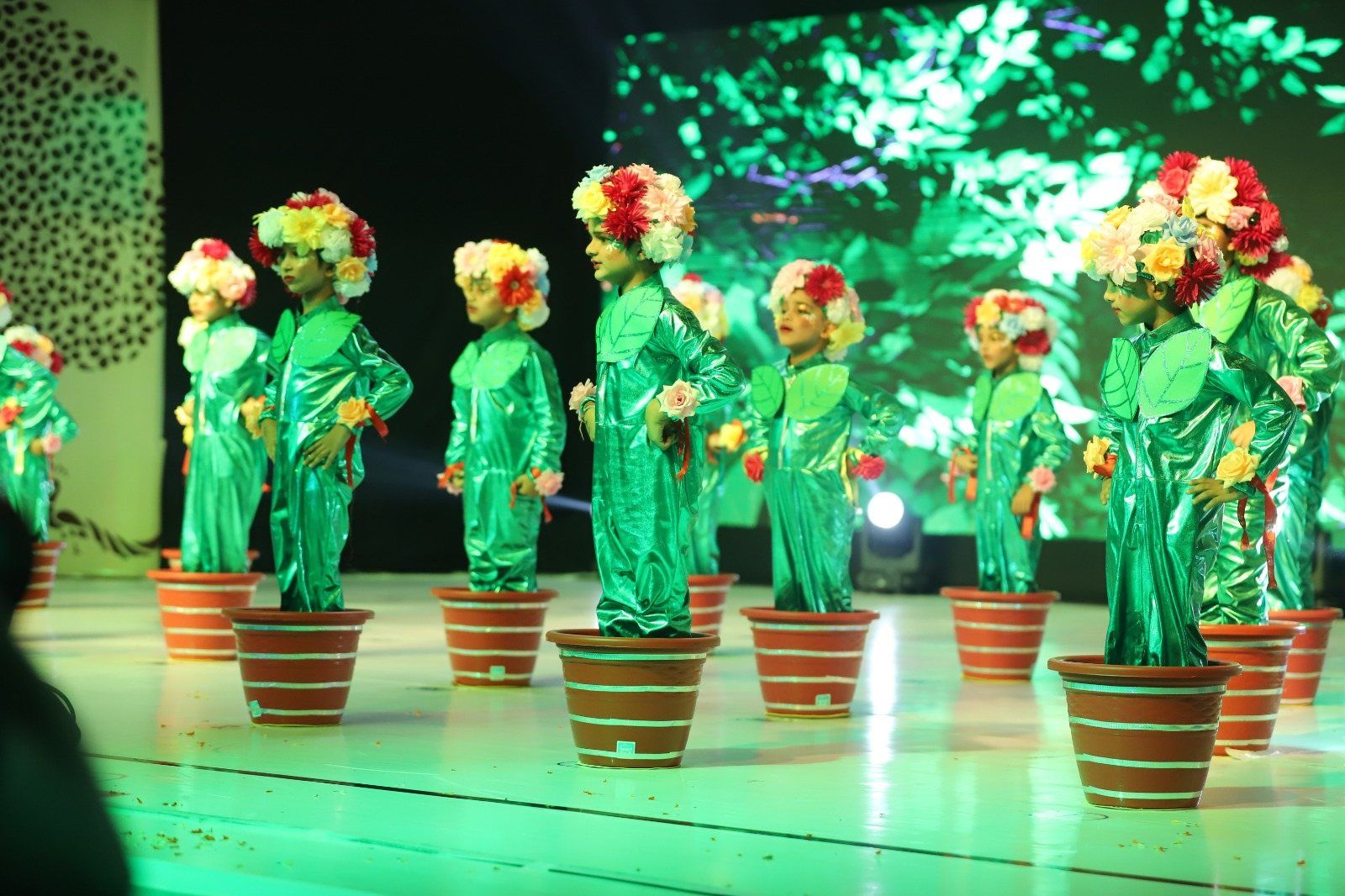 Young performers dressed as potted plants on stage