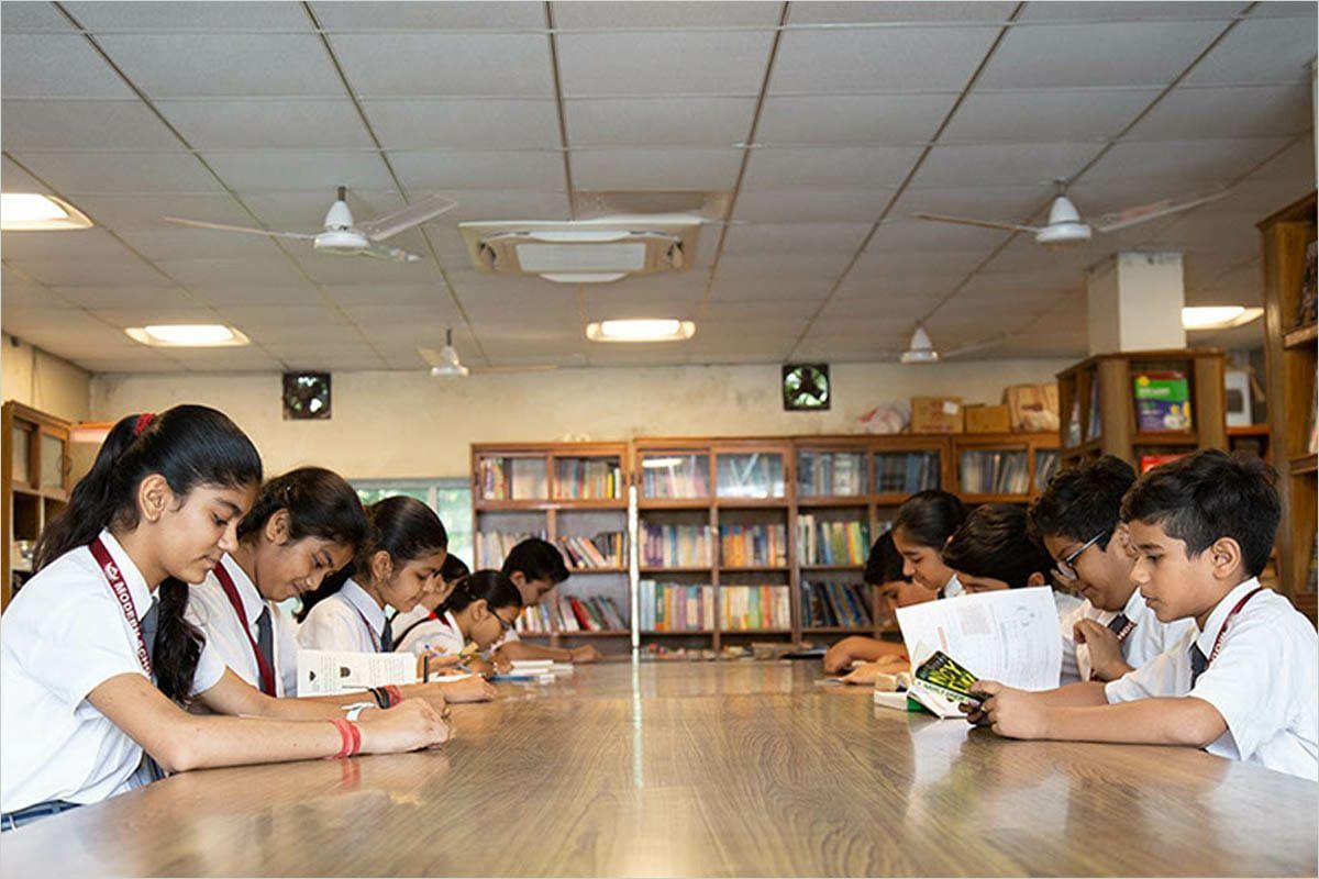 Students reading at the long table in the school library