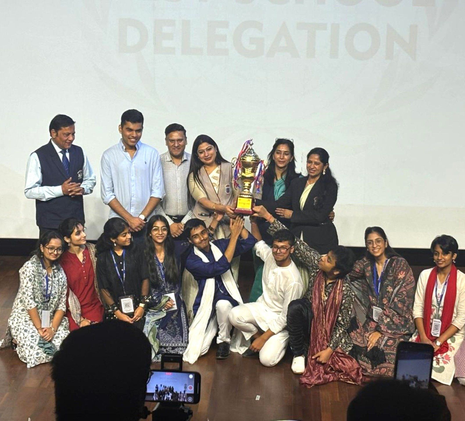 Students and teachers with a trophy won by the school delegation