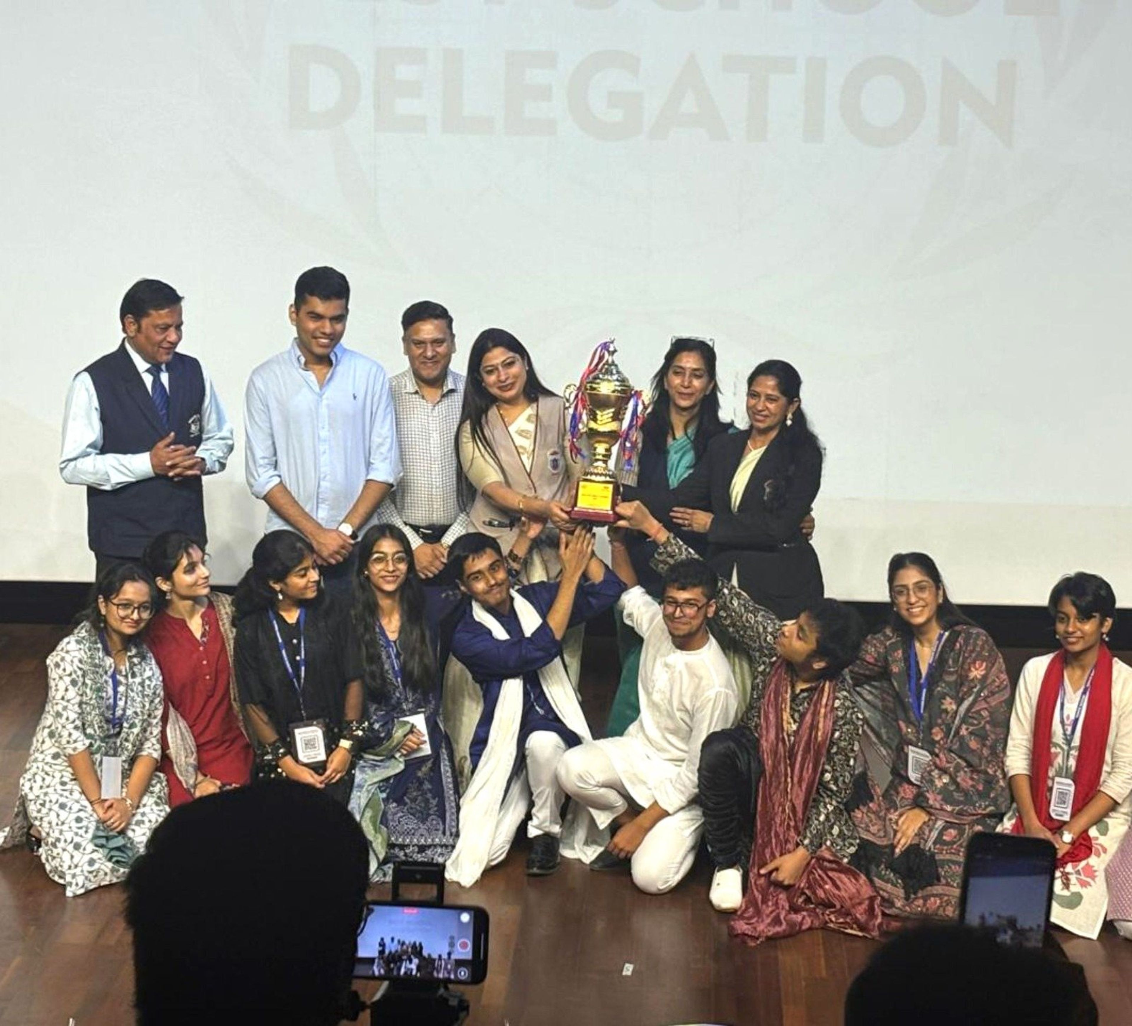 Students and teachers with a trophy won by the school delegation