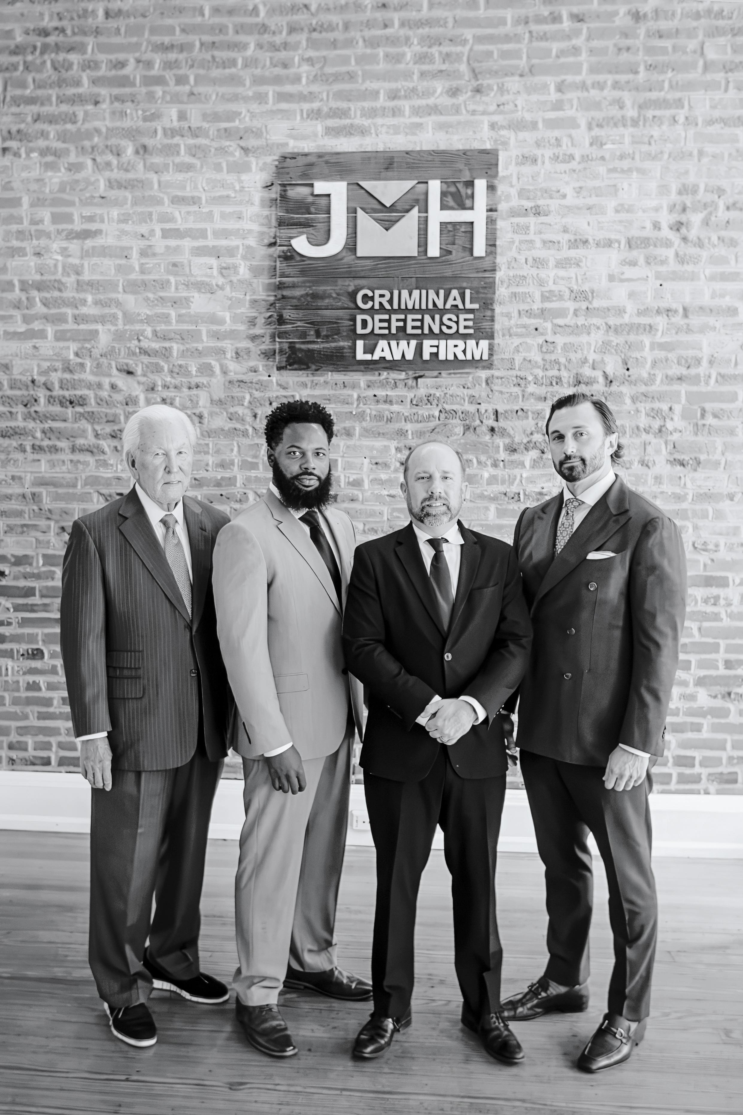 JMH Law Firm attorneys in front of the firm’s sign