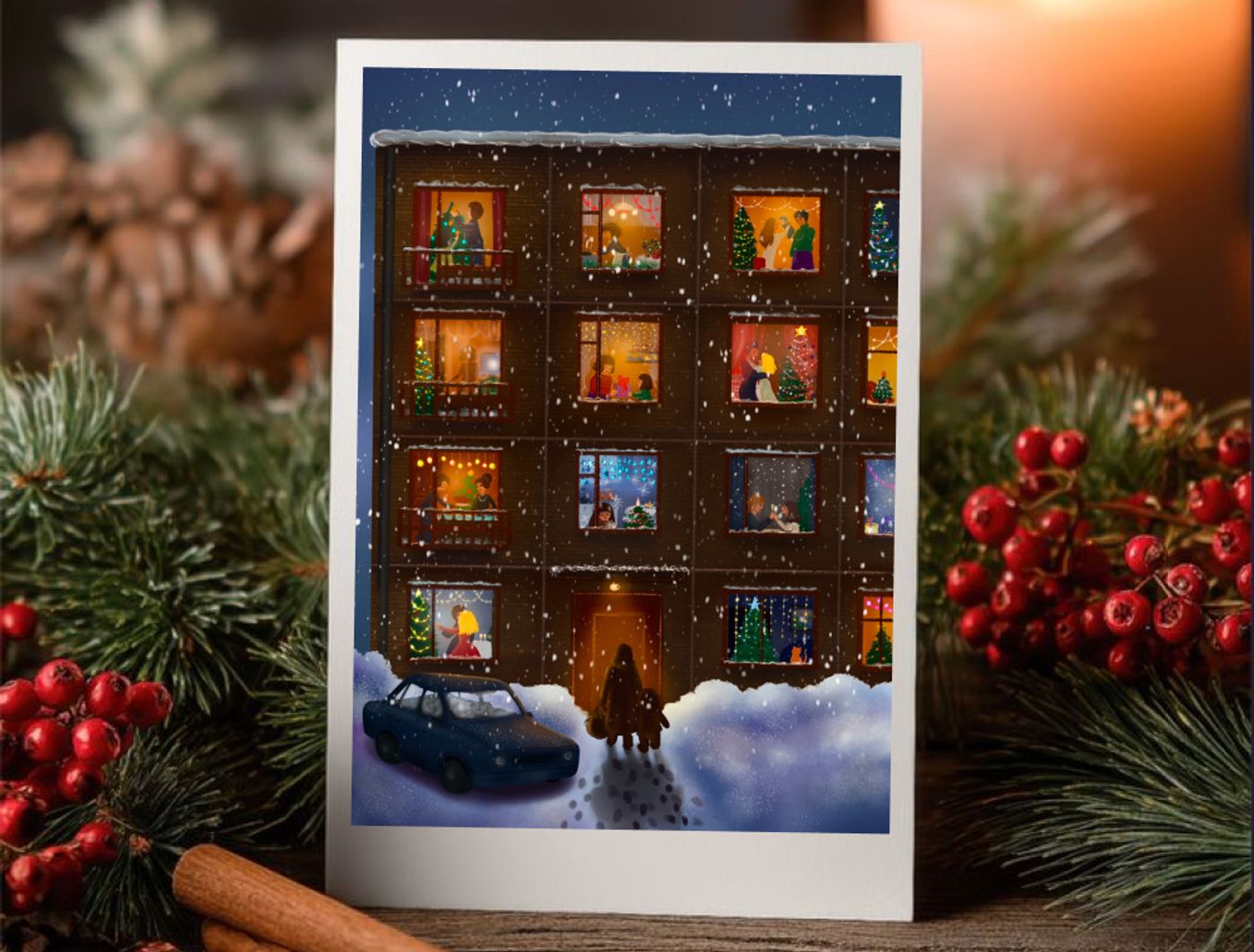 The apartment-block postcard standing on a wooden table between a candle, fir branches and cinnamon sticks