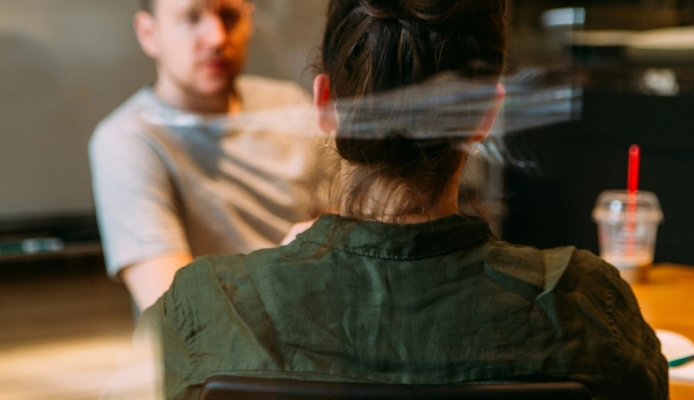 a man and a woman are sitting at a table having a conversation