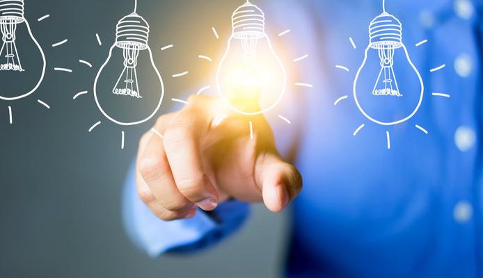 En person peker på en glødende lyspære, som symboliserer ideer eller innsikt. Dette er en illustrasjon.