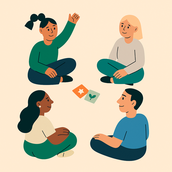 En gruppe mennesker sitter på gulvet og spiller et spill. Den ene rekker opp en hånd.