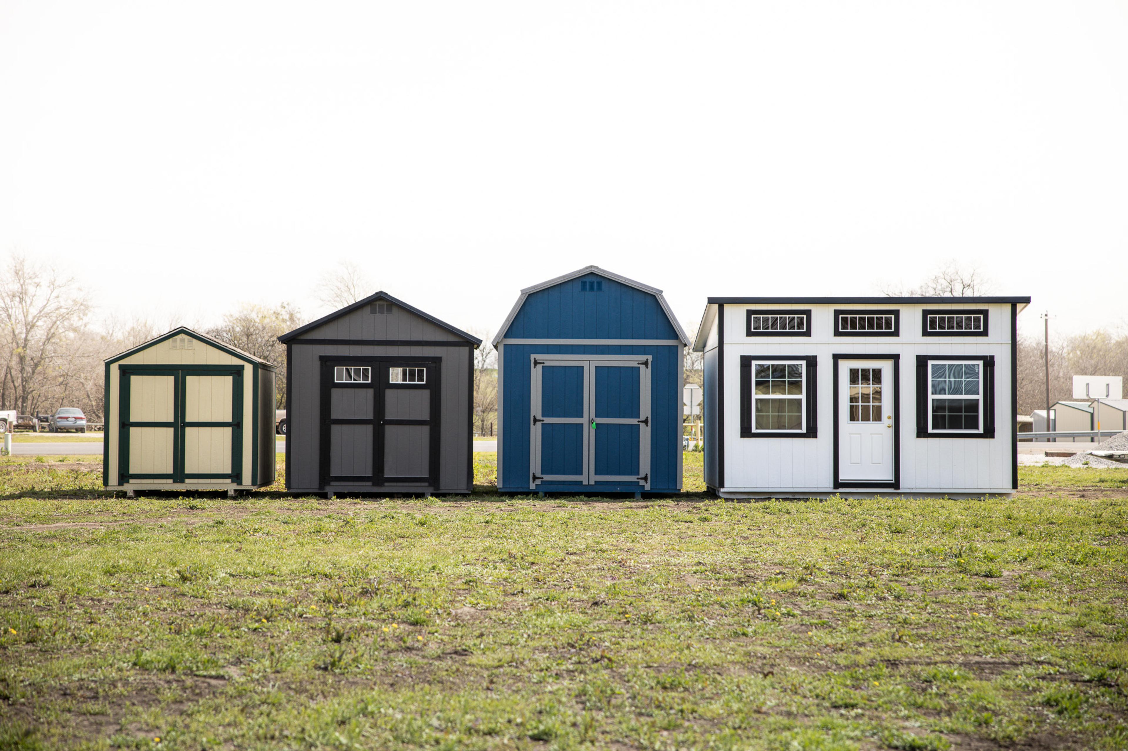 A lineup of Eagle Ridge portable buildings on a Texas property beside a windmill
