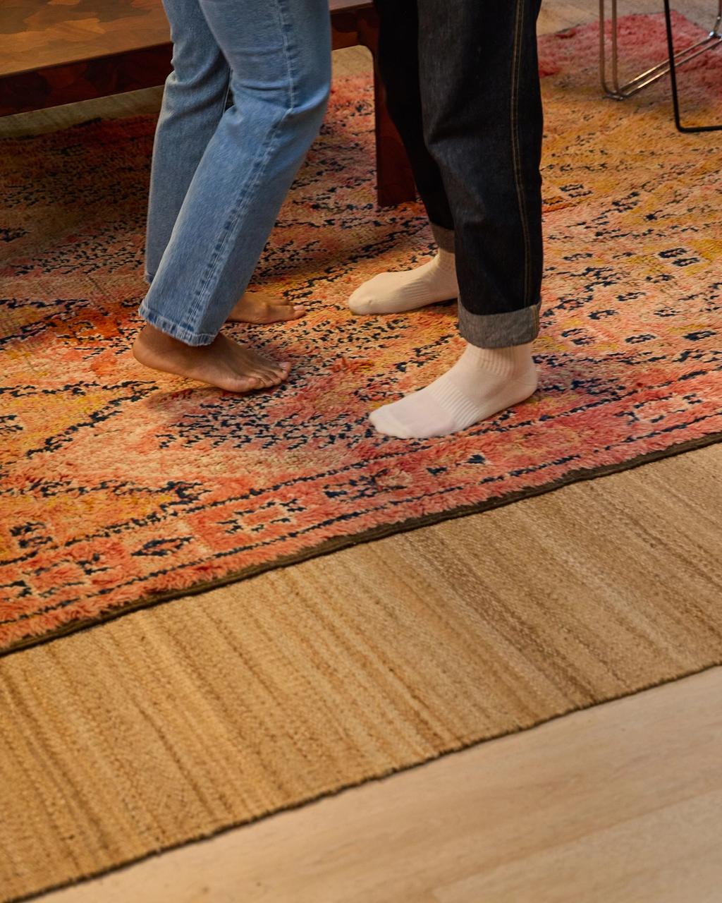Vintage rug layered over a natural jute rug in a living room