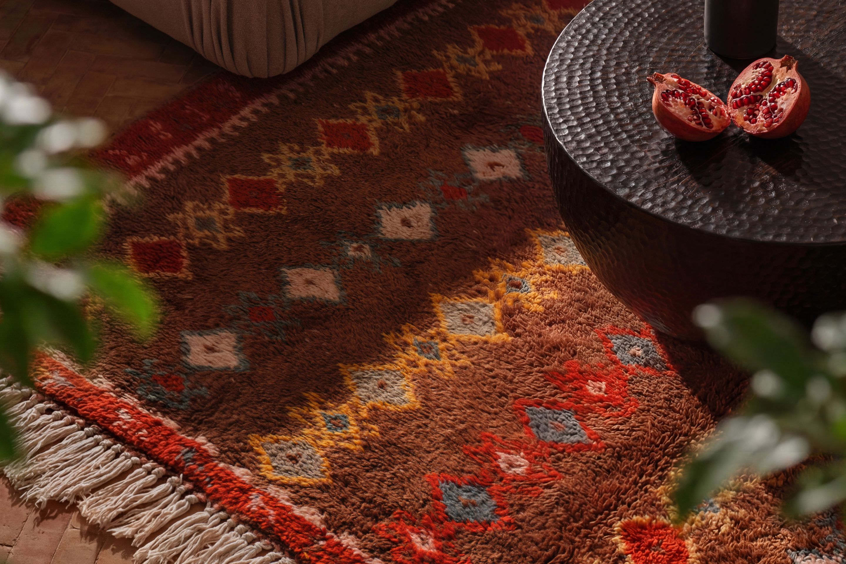 Stack of solid-color rugs in tan, olive green, blue, burgundy, and dark brown