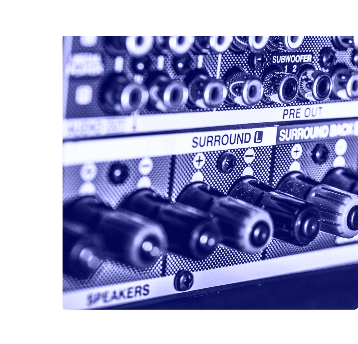 A close-up of the rear panel of a home theater AV receiver showing subwoofer, surround, and speaker binding-post connections.