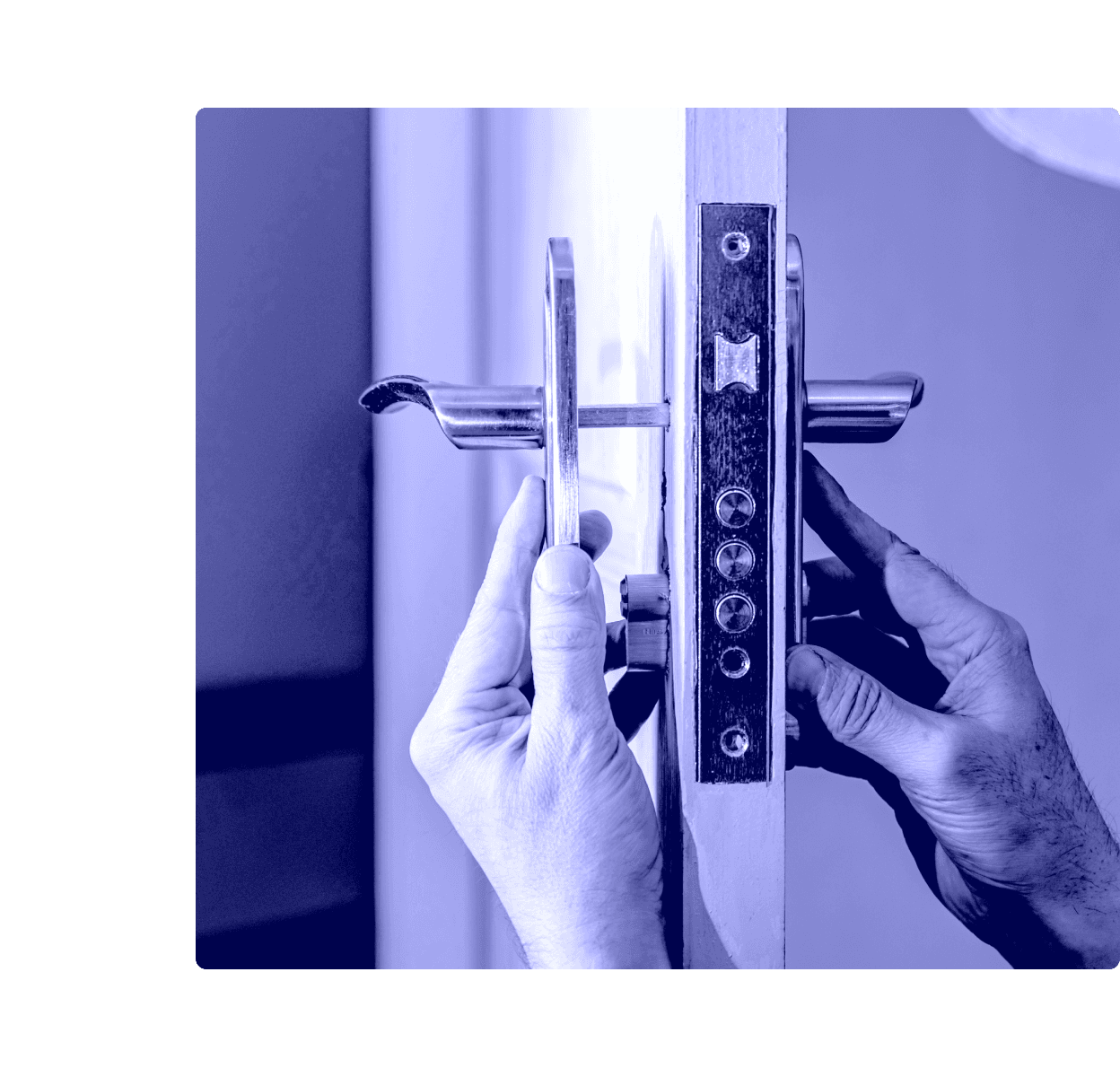 A locksmith's hands fitting a mortise lock and lever handle into a door.