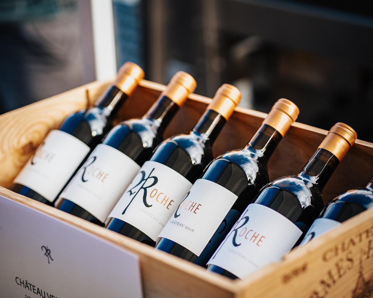 Bottles of Roche wine nestled in a wooden crate from the cellar library