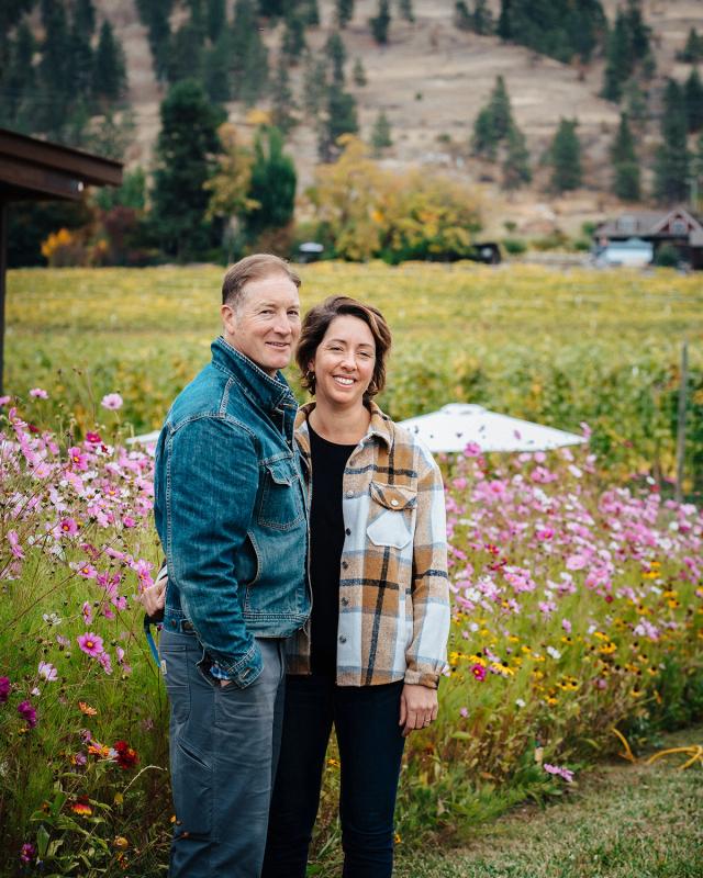 Dylan and Pénélope Roche standing among wildflowers at the Domaine Roche estate vineyard