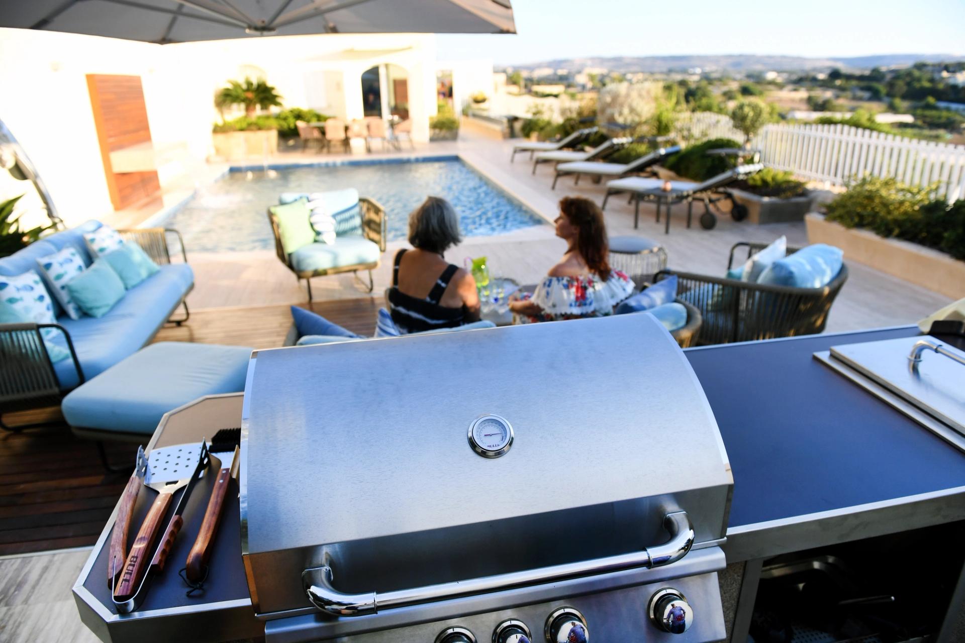 Bull BBQ outdoor kitchen in a poolside backyard at golden hour — pro lifestyle photography