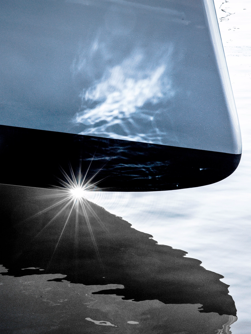 Light reflects on water, revealing the yacht's pure lines in an elegant chiaroscuro