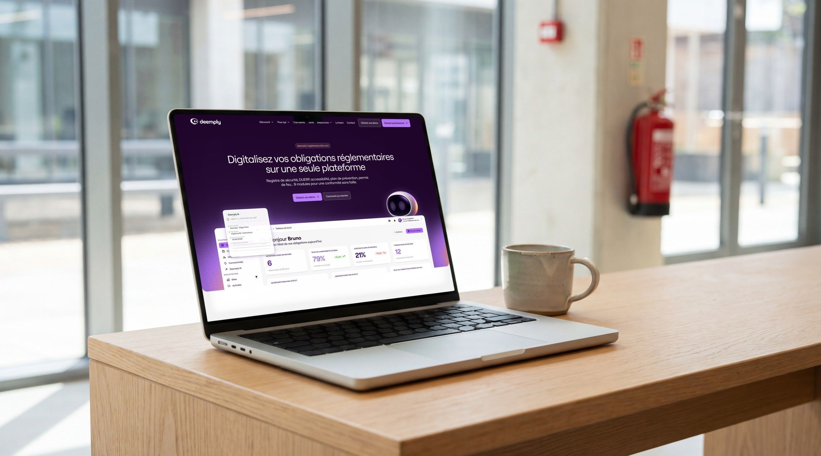 MacBook Pro open on the Deemply home page, “Digitise your regulatory obligations on a single platform”