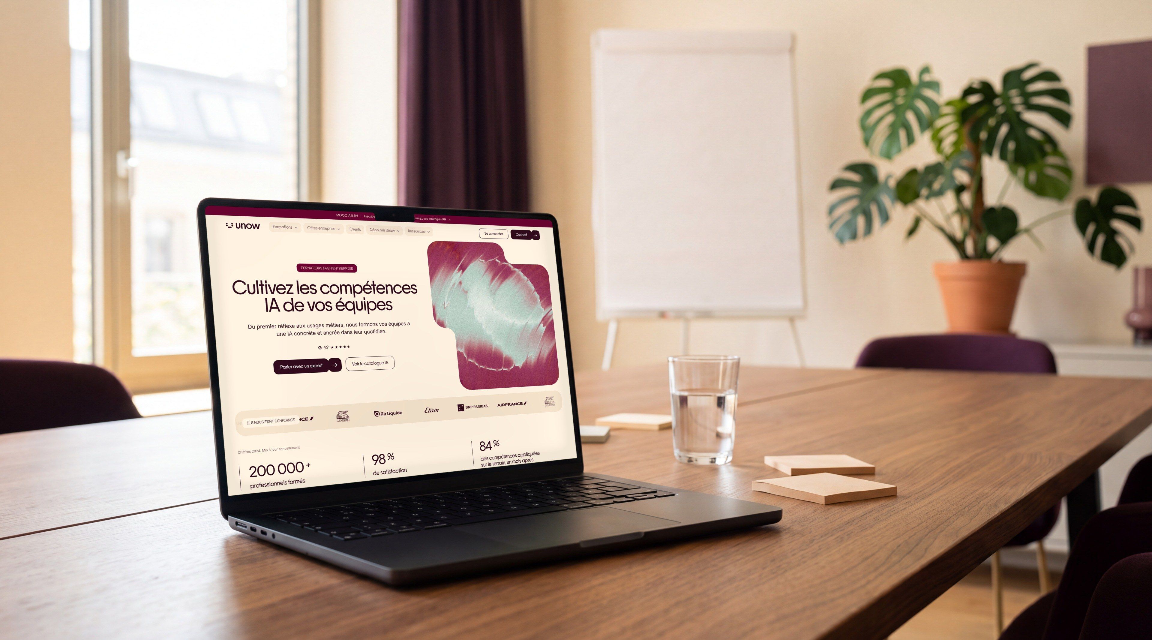 MacBook Pro open on the Unow page “Cultivate your teams' AI skills”