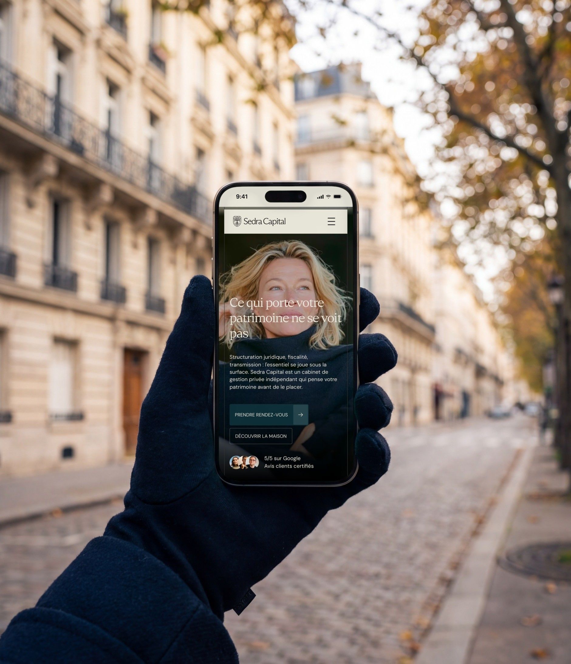 iPhone 16 Pro open on the Sedra Capital mobile home page, on a Parisian avenue