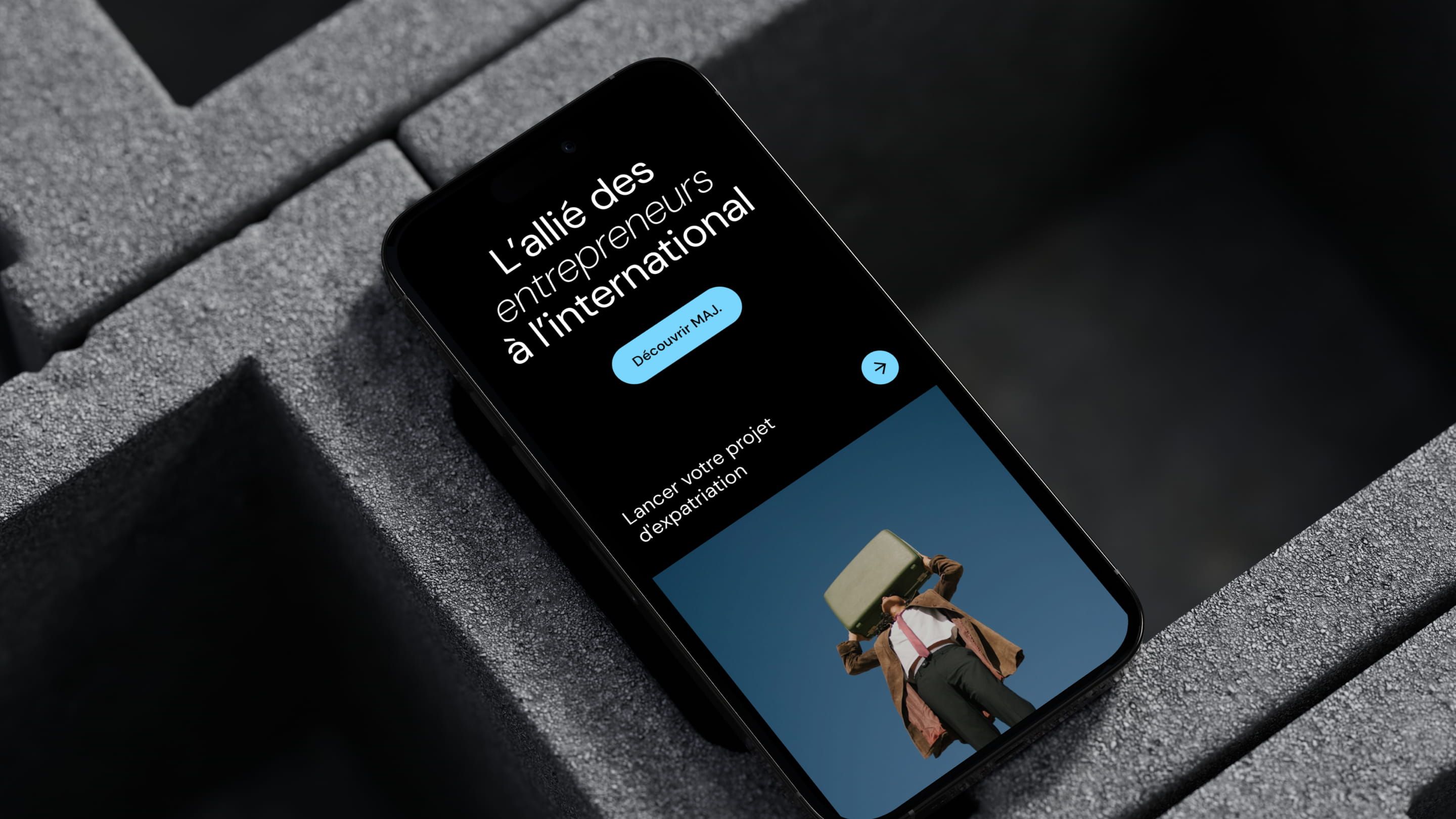 MAJ mobile site on a smartphone: “L'allié des entrepreneurs à l'international” and a “Découvrir MAJ.” button