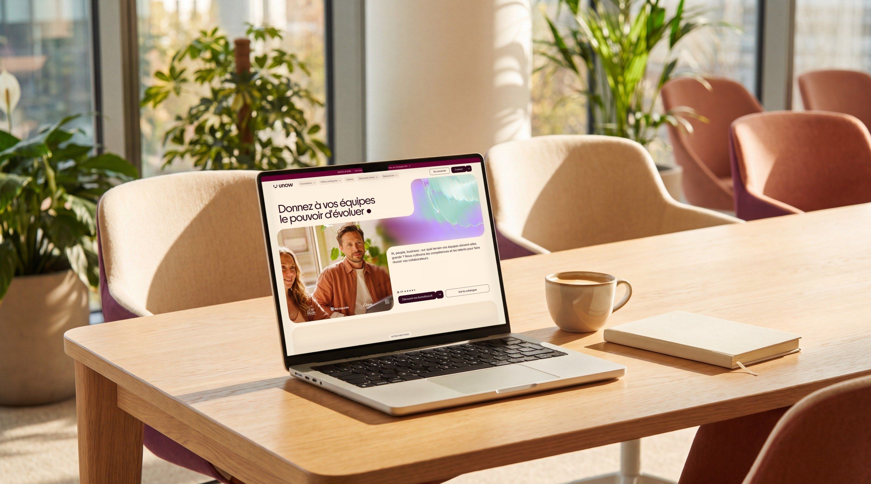 MacBook Pro open on the Unow home page, “Give your teams the power to grow”