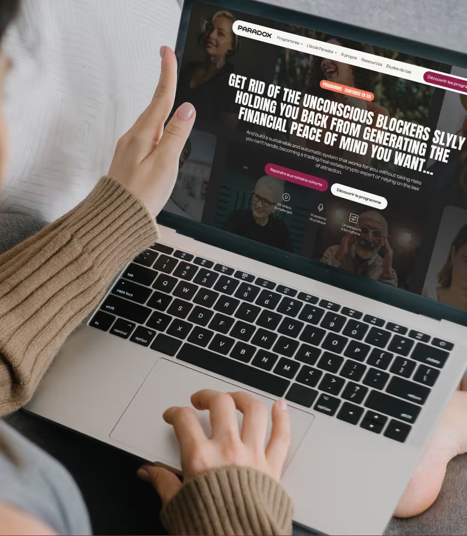 Person using a laptop showing the Paradox website homepage: “Get rid of the unconscious blockers…”