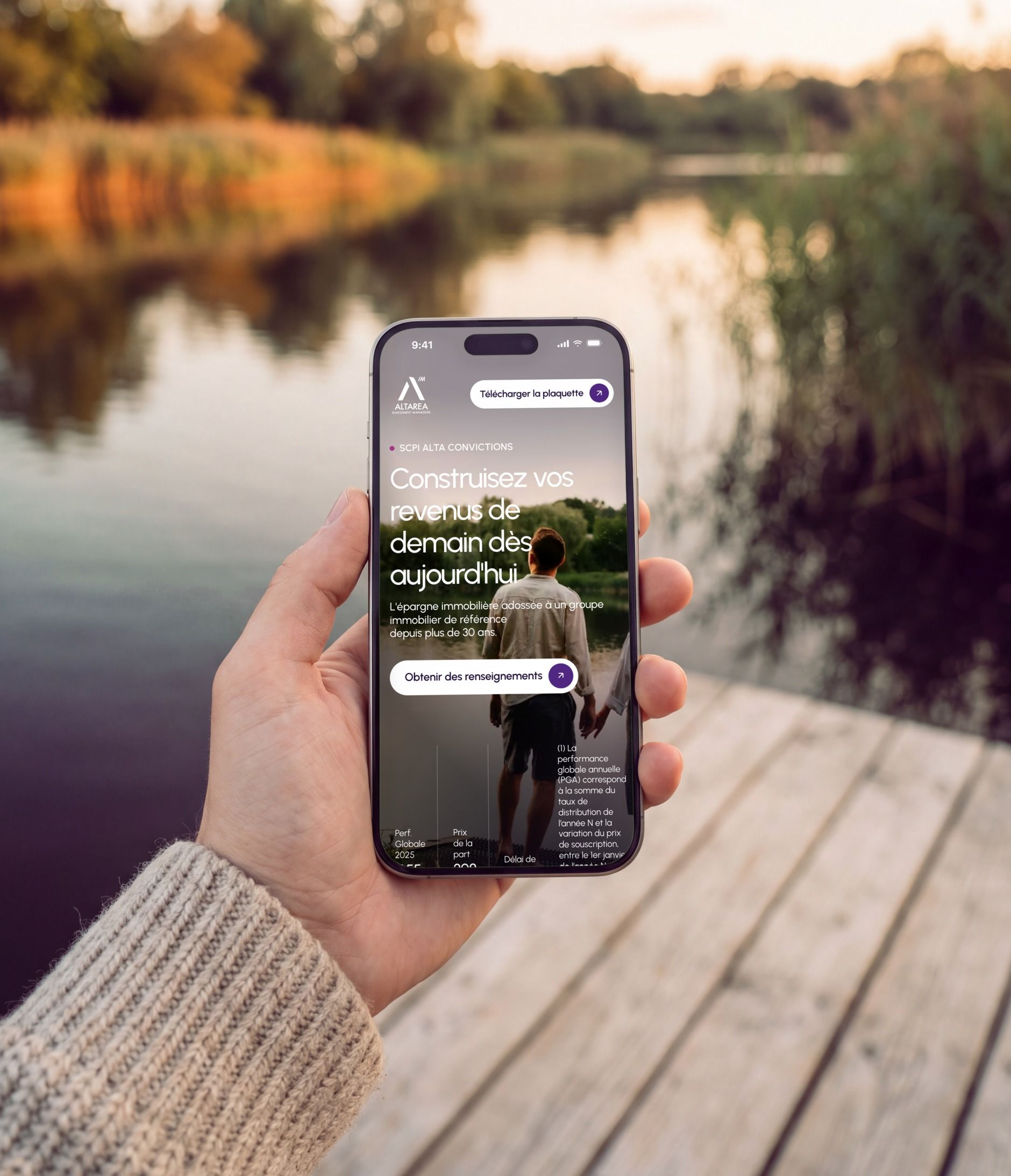 iPhone 16 Pro held by a lake, open on the page's first mobile screen