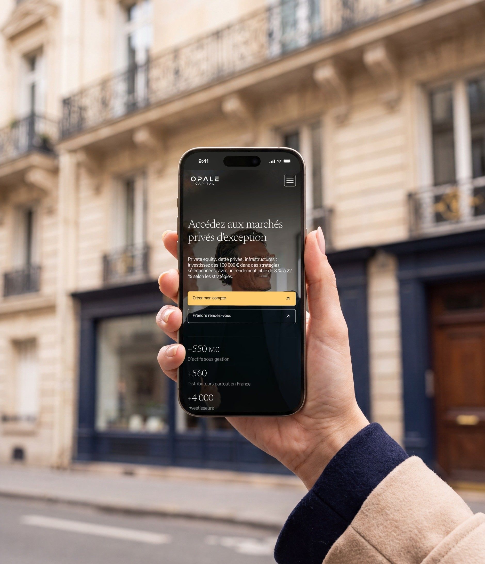 iPhone 16 Pro held in front of a Haussmann-style façade, open on the Opale Capital mobile home page