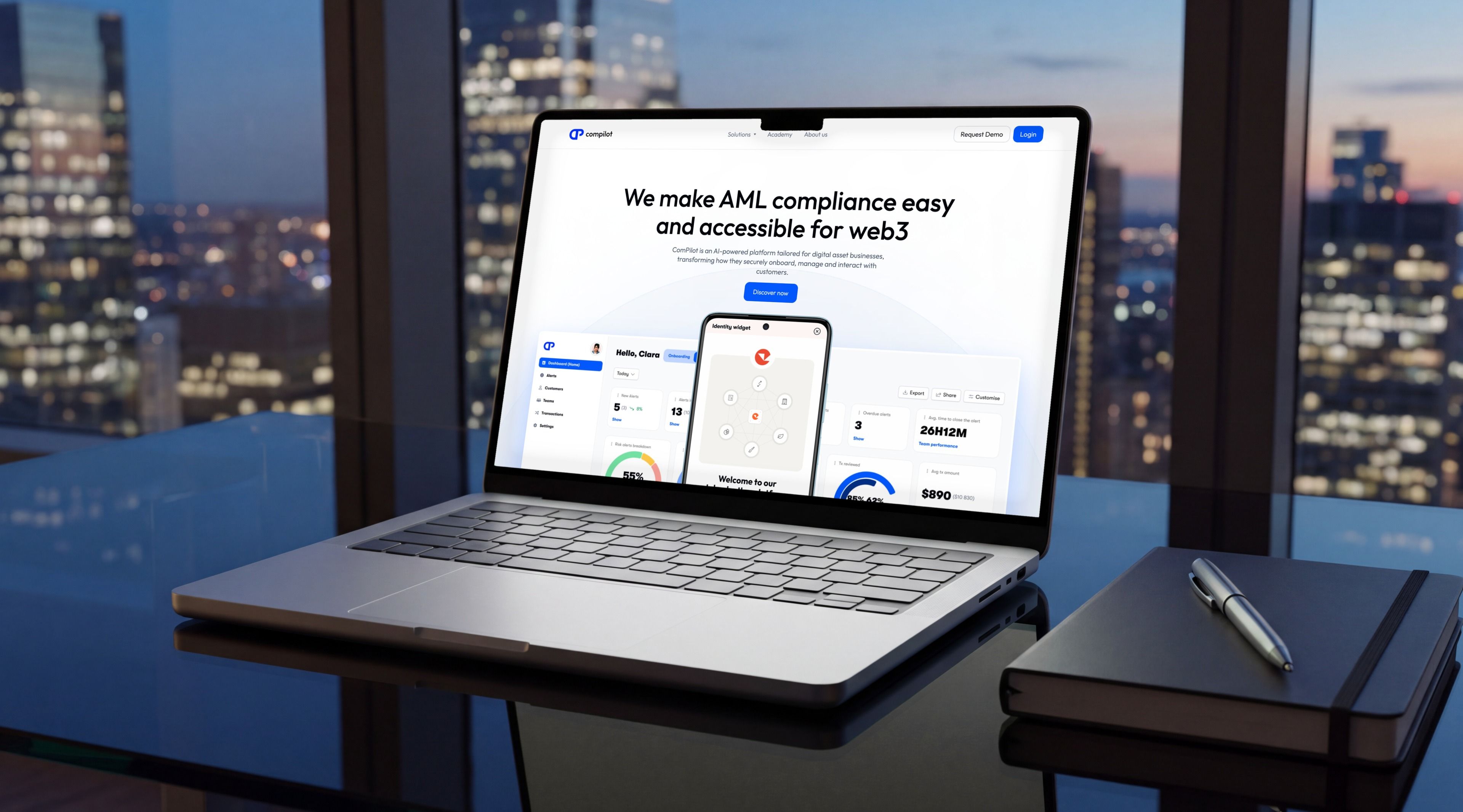 MacBook Pro sur un bureau en verre d'un quartier d'affaires au crépuscule, ouvert sur l'accueil Compilot « We make AML compliance easy and accessible for web3 »