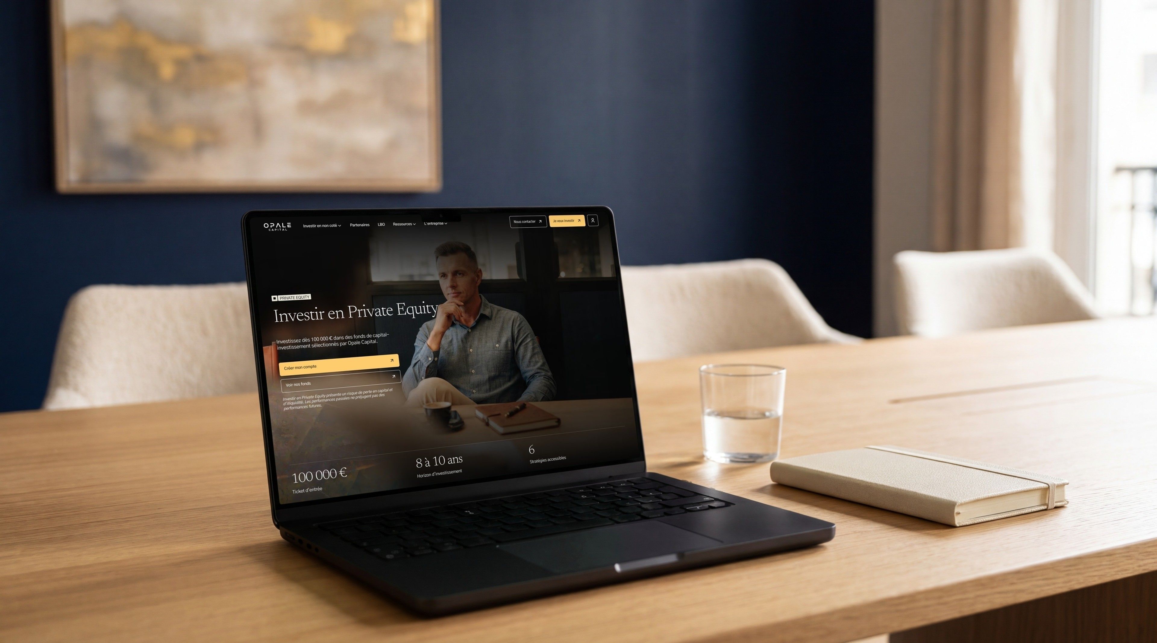MacBook Pro open on Opale Capital's “Investing in Private Equity” page, on a meeting table