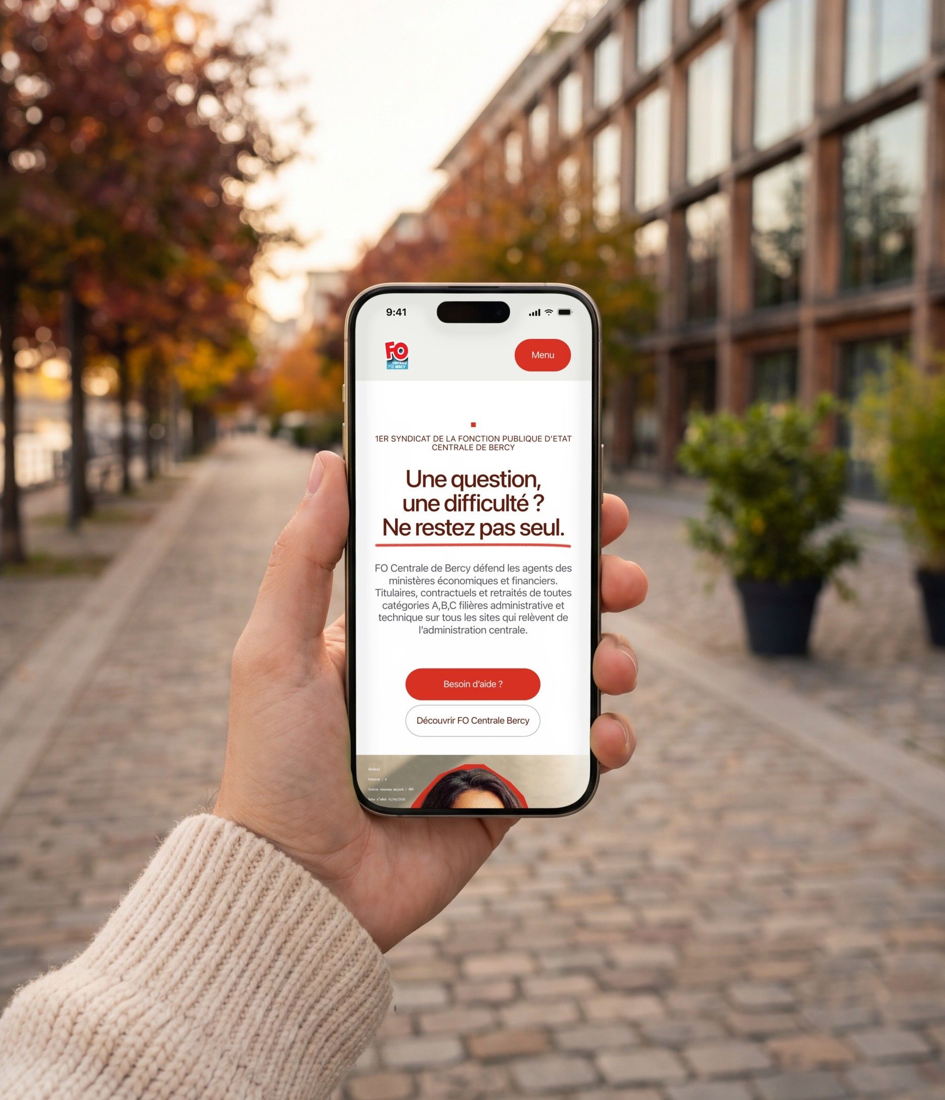 iPhone 16 Pro open on the FO Centrale Bercy mobile home page, by a tree-lined walkway