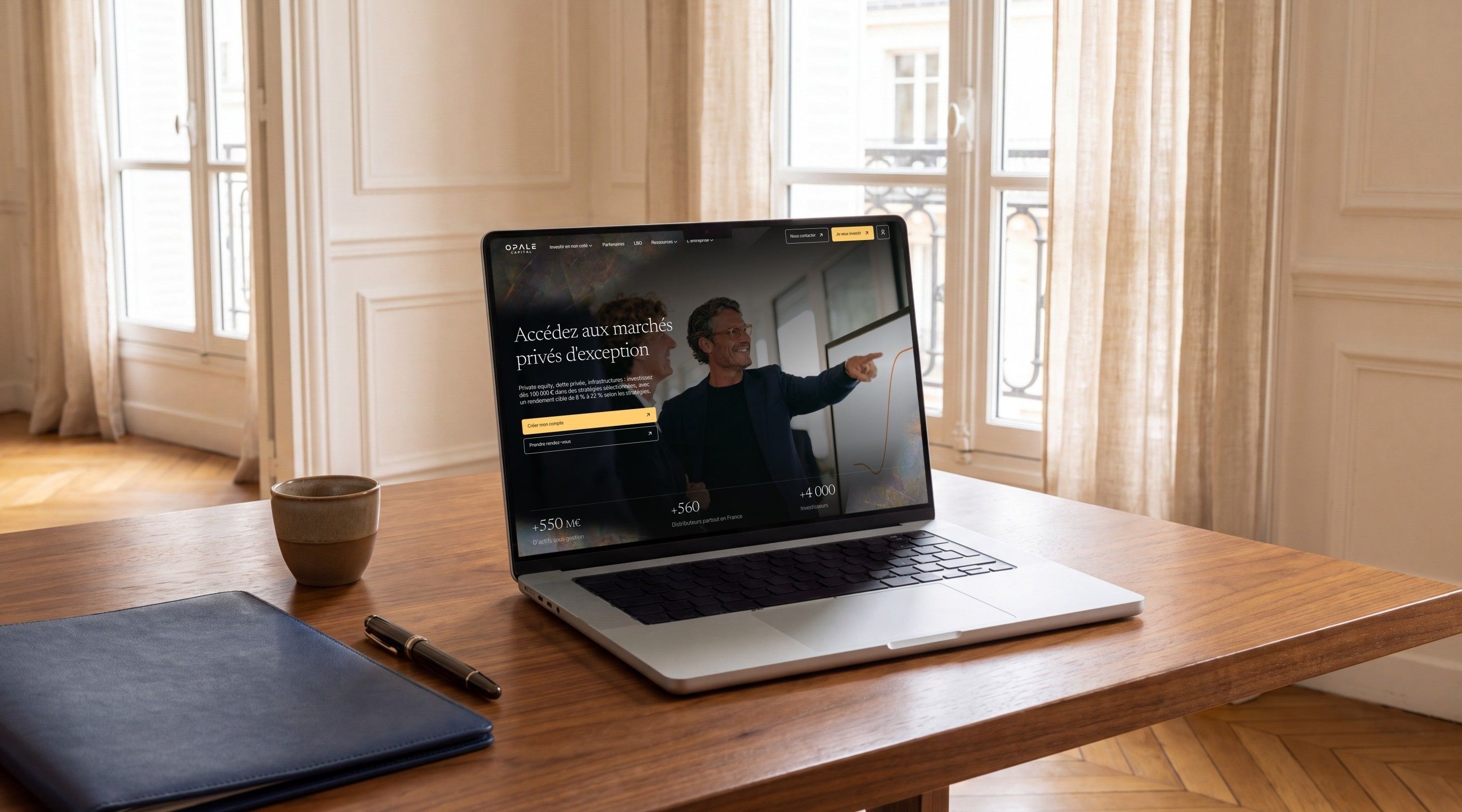 MacBook Pro open on the Opale Capital home page, “Access exceptional private markets”, on a walnut desk