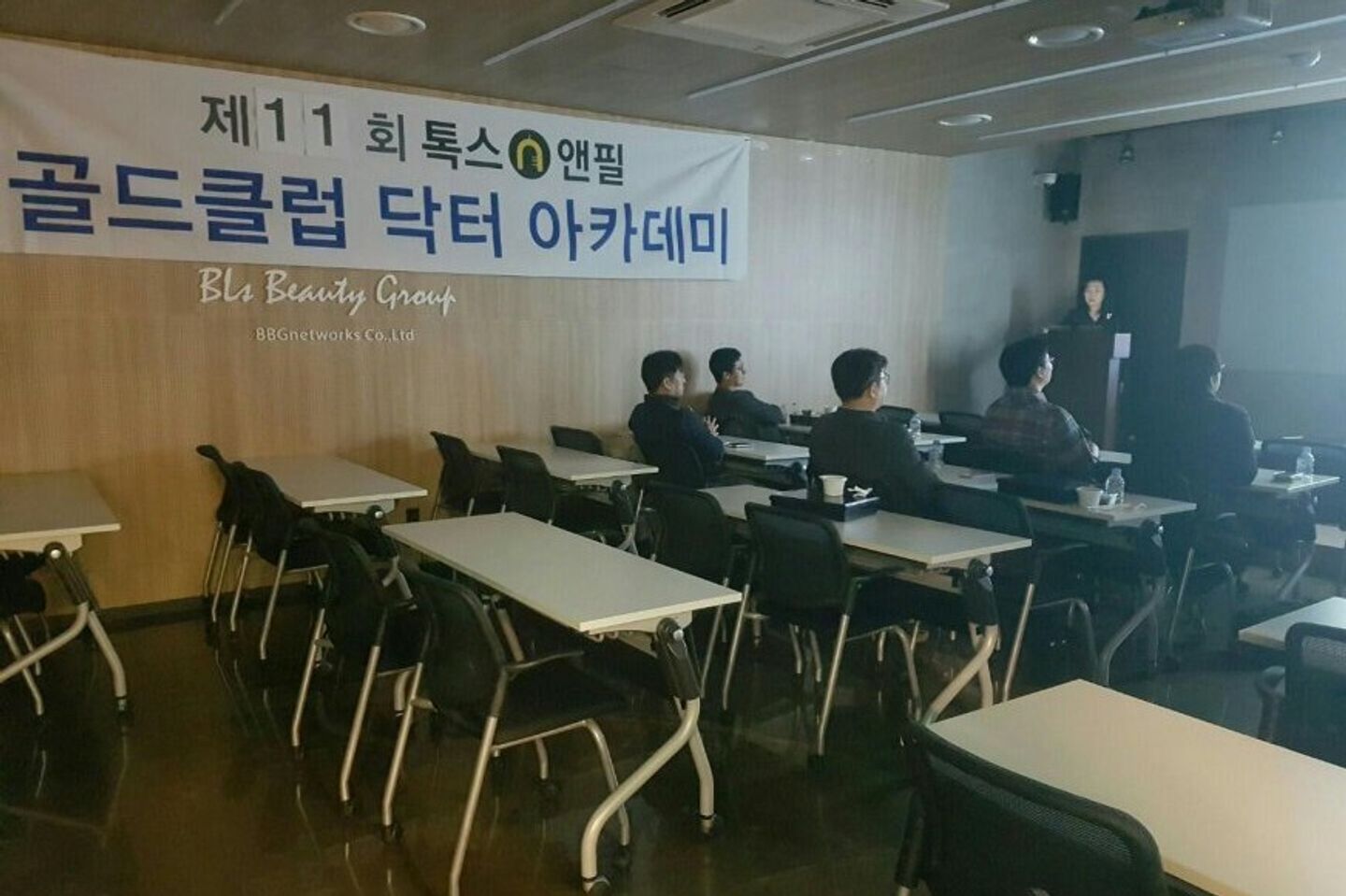 '제11회 톡스앤필 골드클럽 닥터 아카데미' 현수막 아래 참석자들이 책상에 앉아 앞쪽 단상을 바라보는 모습