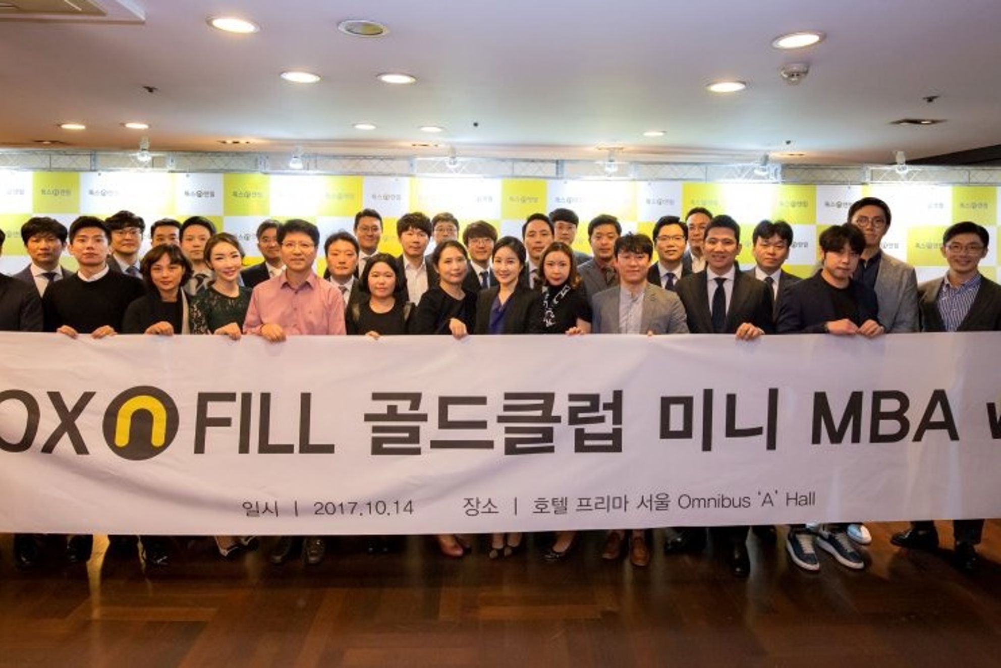 톡스앤필 로고가 반복된 노란색·흰색 배경 벽 앞에서 참석자들이 행사 이름이 적힌 흰 현수막을 함께 들고 여러 줄로 선 단체 사진