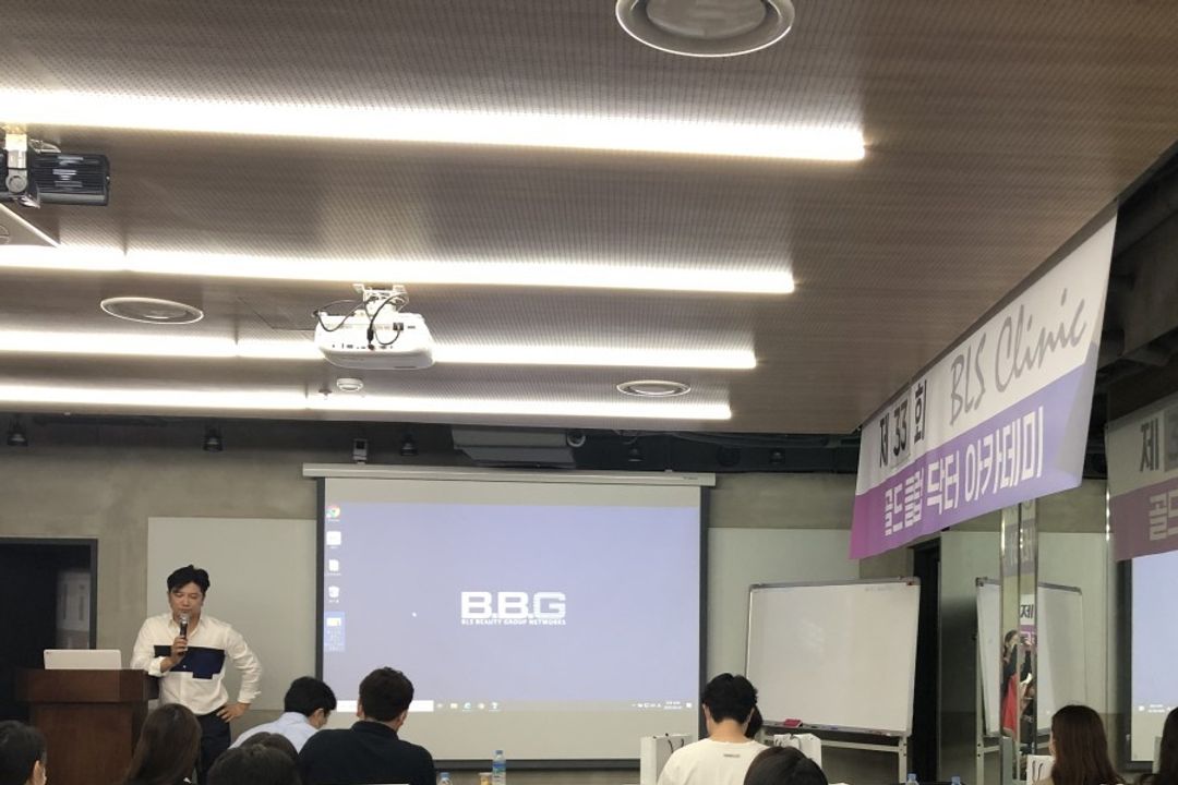 현수막이 걸린 강의실에서 참석자들이 앉아 앞쪽 연단을 향한 장면