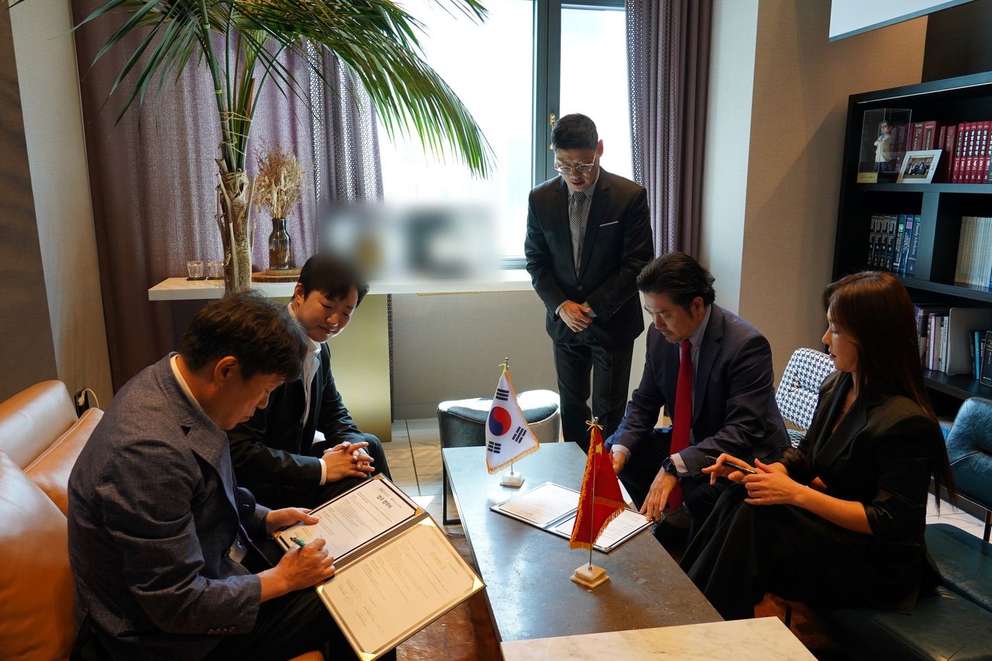 한국과 중국 국기를 올린 탁자 주변에서 참석자들이 협약서를 펼쳐 서명하고 있다