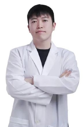 흰 배경 앞에서 흰 가운을 입고 팔짱을 낀 한 사람의 상반신 프로필 사진