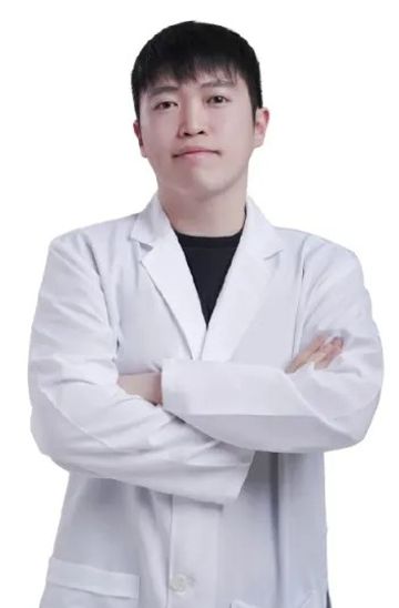 흰 배경 앞에서 흰 가운을 입고 팔짱을 낀 한 사람의 상반신 프로필 사진