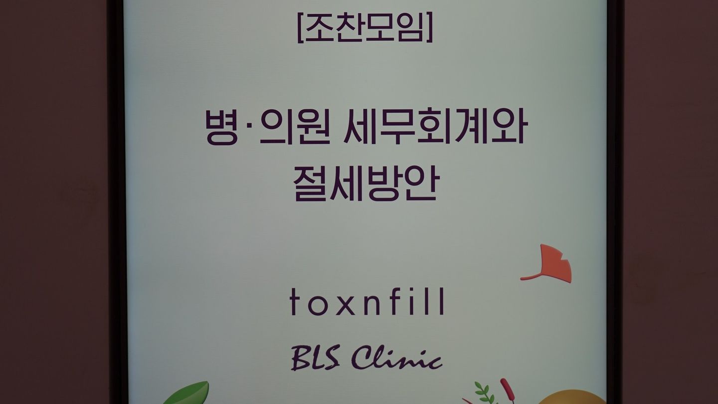 안내판에 '[조찬모임]', '병·의원 세무회계와 절세방안' 글자와 toxnfill·BLS Clinic 로고가 표시돼 있다