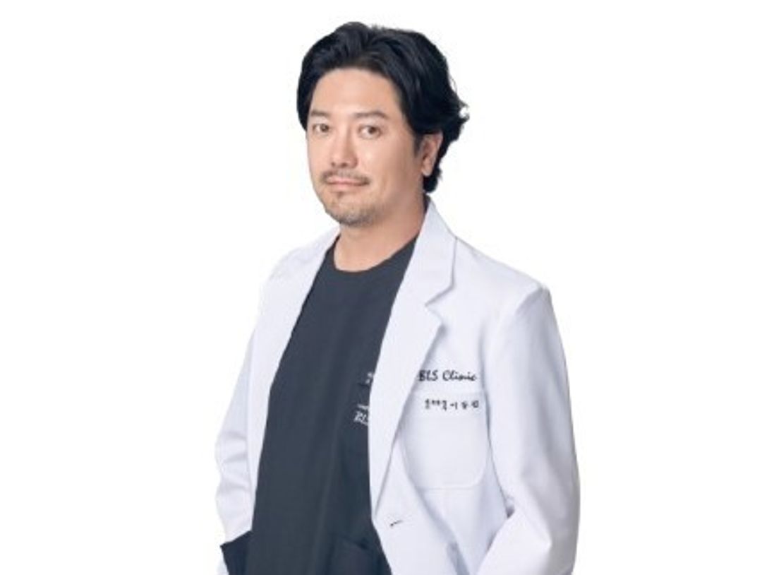 흰 배경 앞에서 흰 가운을 입은 한 사람의 상반신 프로필 사진