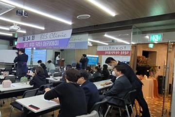 골드 클럽 닥터 아카데미 현수막이 걸린 강의장에서 참석자들이 책상에 앉아 앞쪽 연단과 화면을 바라보는 모습