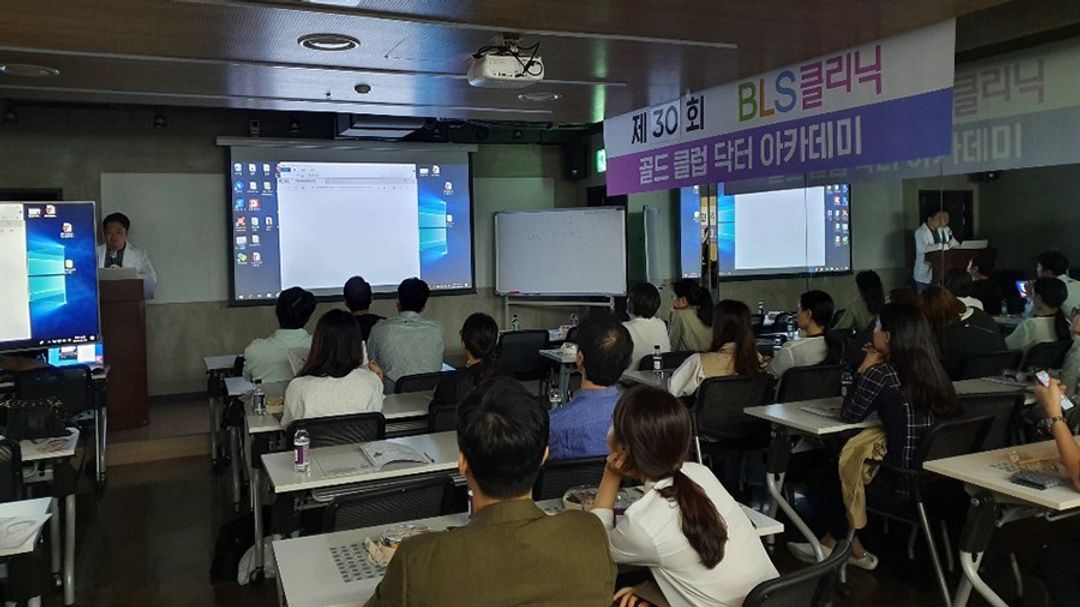 현수막이 걸린 강의실에서 참석자들이 앉아 연단 쪽을 향한 장면