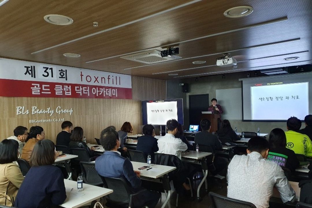 현수막이 걸린 강의실에서 참석자들이 앉아 연단 쪽을 향한 장면
