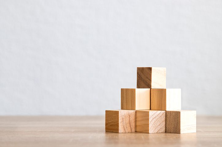 A photo of wooden building blocks stacked on top of each other.