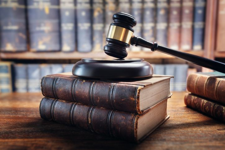 A judge's gavel is resting on a stack of books.
